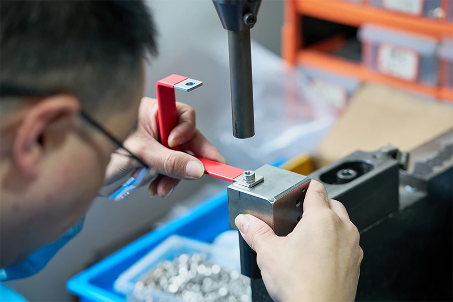 Worker positioning an insulated flexible busbar in a fixture