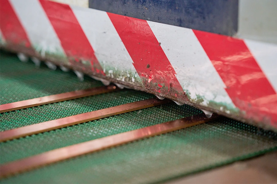 Copper strips passing through processing equipment
