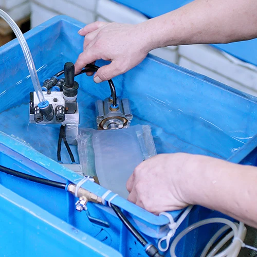 Operator working on a metal assembly at a fixture