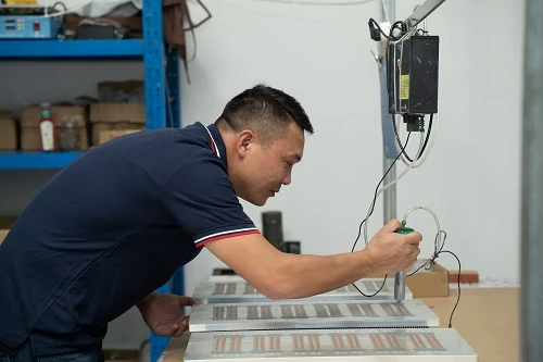 Operator checking an aluminium cold plate at the workstation