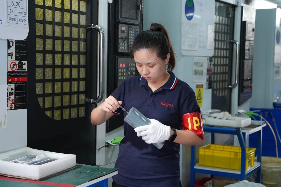 Operator inspecting a component beside the production line